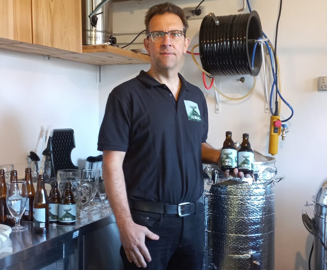 Bierbrouwer Stefan toont zijn atelier en houdt 2 flessen Keiberg vast
